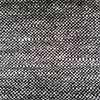 Woven fabric sample, gray and black, irregular dot pattern; dense plain weave texture with visible threads, matte finish, “ditre italia” label.